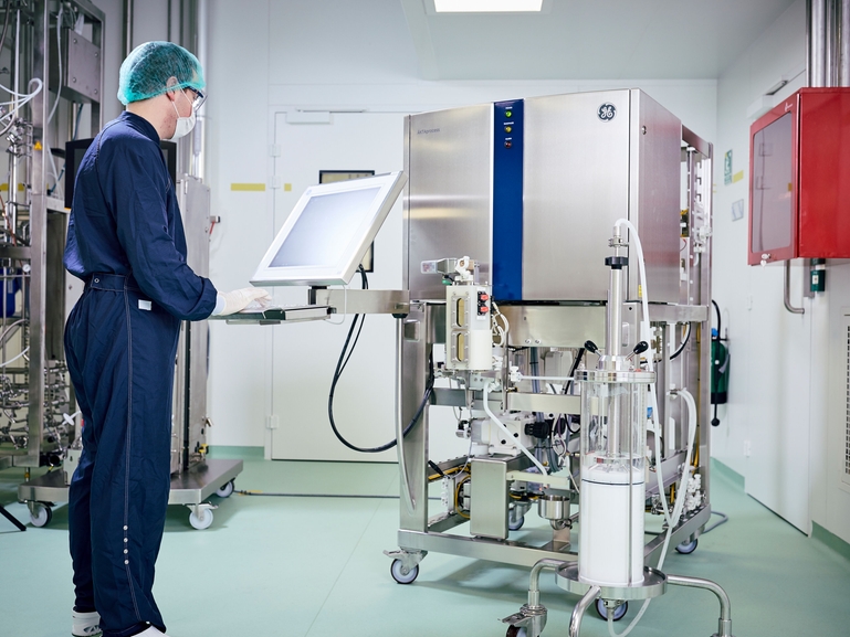 Scientist with chromatography skid in Life Science industry Chromatography skid for downstream bioprocessing with scientist
